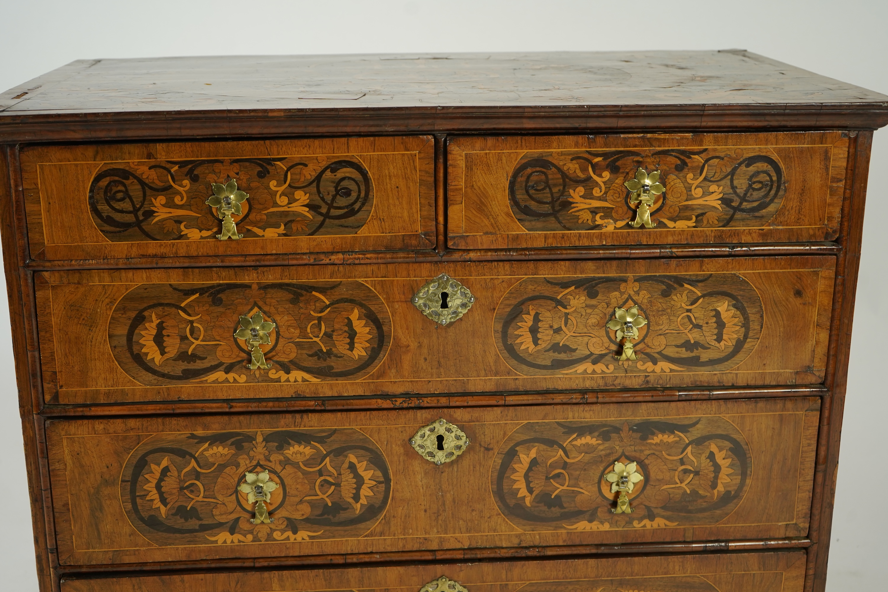 A William and Mary walnut and floral marquetry chest on later bracket feet